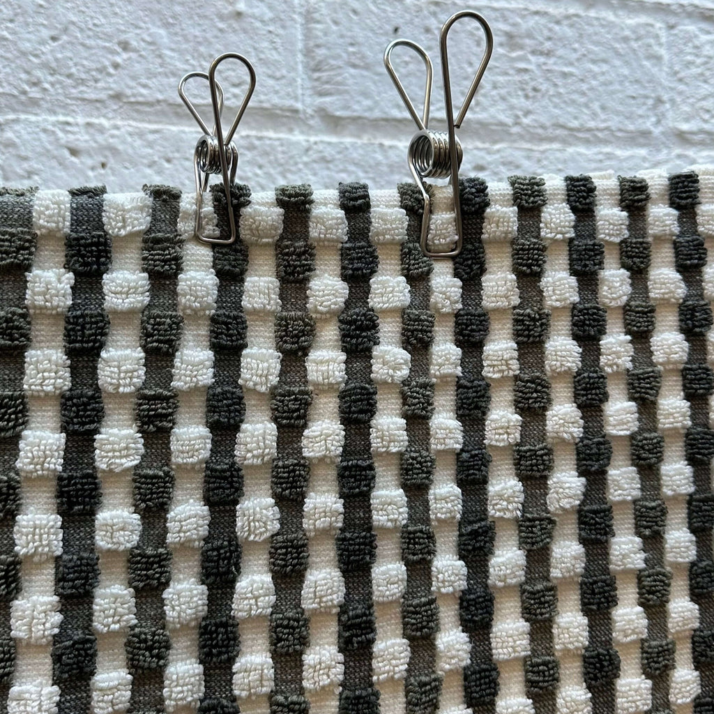 Stainless Steel pegs on green and white checked bath towel hanging on clothesline