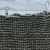 Stainless Steel pegs on green bathmat hanging on clothesline