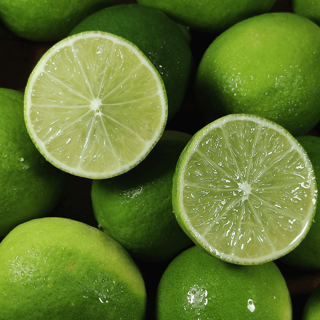 Green limes with one sliced open, showing a close-up of the fruit's interior.