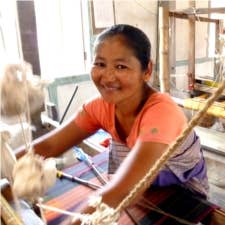 Indian Artisan in orange top hand weaving cotton serviettes