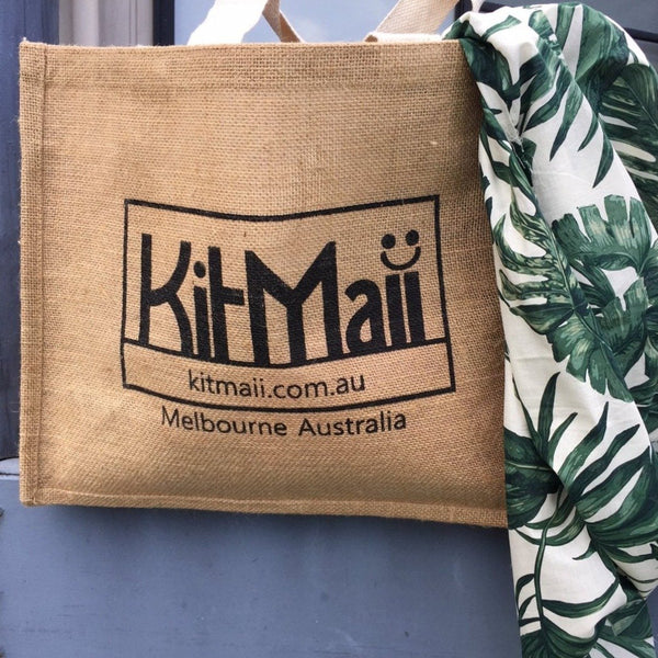 jute shopping bag with handy pockets with green and cream floral sarong ready for the beach